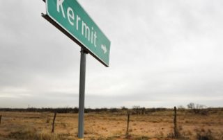 Kermit Sign pointing towards barren field